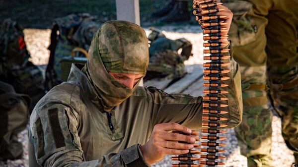 Военный во время тренировки армейской тактической стрельбы из пулемета Калашникова