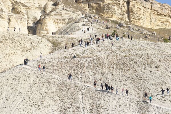 Туристы забираются на Белую скалу