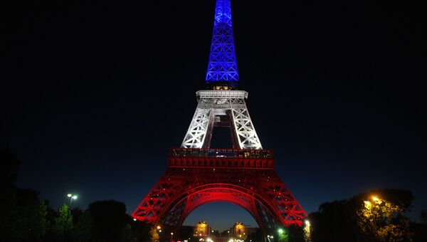 Эйфелева башня в Париже, подсвеченная в цвета французского флага.