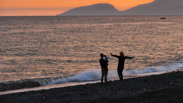Люди гуляют по побережью Черного моря