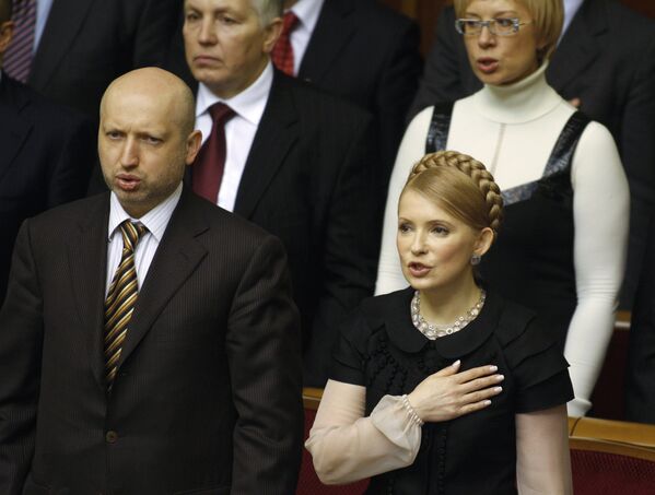Первый вице-премьер Украины Александр Турчинов и премьер-министр Украины Юлия Тимошенко (на первом плане) исполняют государственный гимн во время открытия четвертой сессии Верховной Рады.