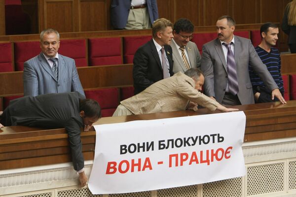 Депутаты фракции БЮТ (блок Юлии Тимошенко) вывешивают предвыборный слоган на балконе Верховной Рады.
