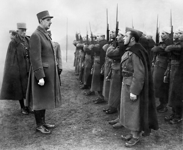  Шарль де Голль (в центре), главнокомандующий Свободными силами Франции, инспектирует французские колониальные войска во время посещения военной базы в Великобритании 24 января 1941 года во время Второй мировой войны