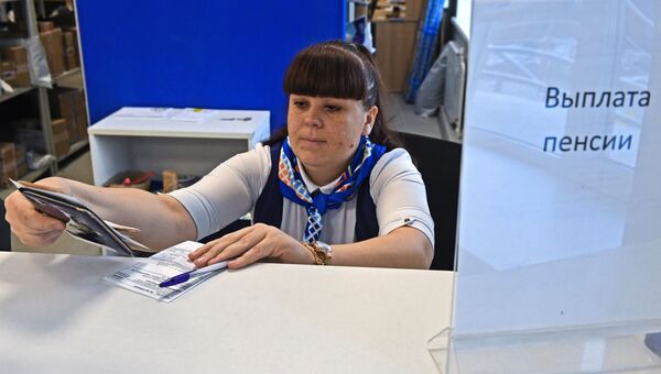 Сотрудница Почты России выдает пенсию в Первомайском районе города Новосибирска