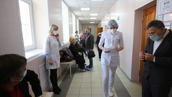 Пациенты у процедурного кабинета перед прививкой от коронавируса вакциной Спутник-V (Гам-КОВИД-Вак) в районной больнице в Волгограде