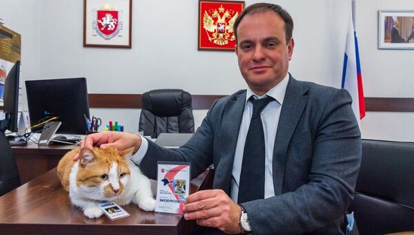 Министр курортов и туризма Крыма В. Волченко вручает удостоверение экскурсовода коту Мостику