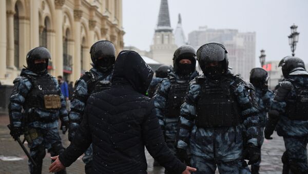 Мужчина разговаривает с сотрудниками правоохранительных органов во время несанкционированной акции сторонников Алексея Навального в Москве