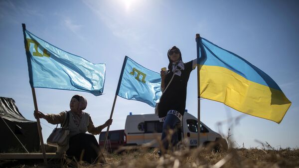Женщины держат флаги Украины и крымских татар 