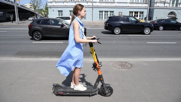Девушка катается на электросамокате на улице Остоженке в Москве. Архивное фото