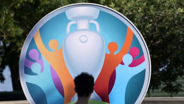 Мужчина проходит мимо вывески, рекламирующей предстоящий чемпионат Европы по футболу 2020 года в Баку, Азербайджан. 10 июня 2021 года