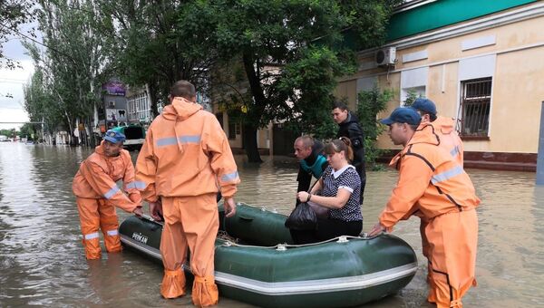 Спасатели эвакуируют людей на лодке во время подтопления в Керчи