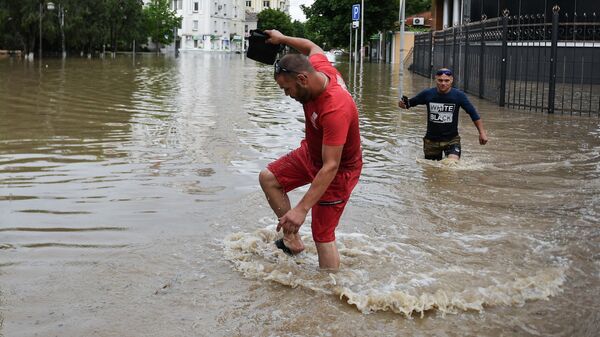 Мужчины на одной из улиц Керчи после сильных ливней
