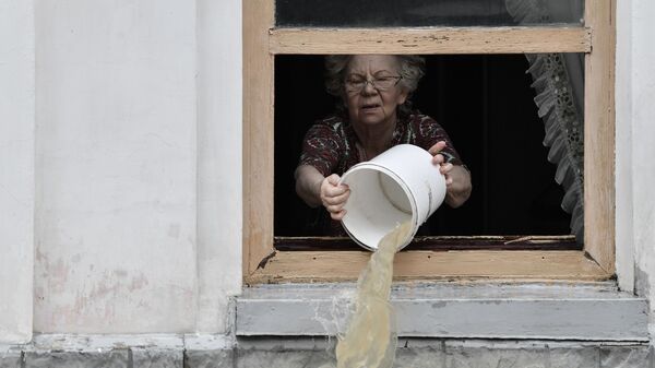 Жительница Керчи вычерпывает воду из дома ведром