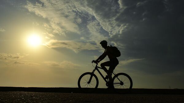 Велосипедист на пляже в поселке Новофедоровка в Крыму