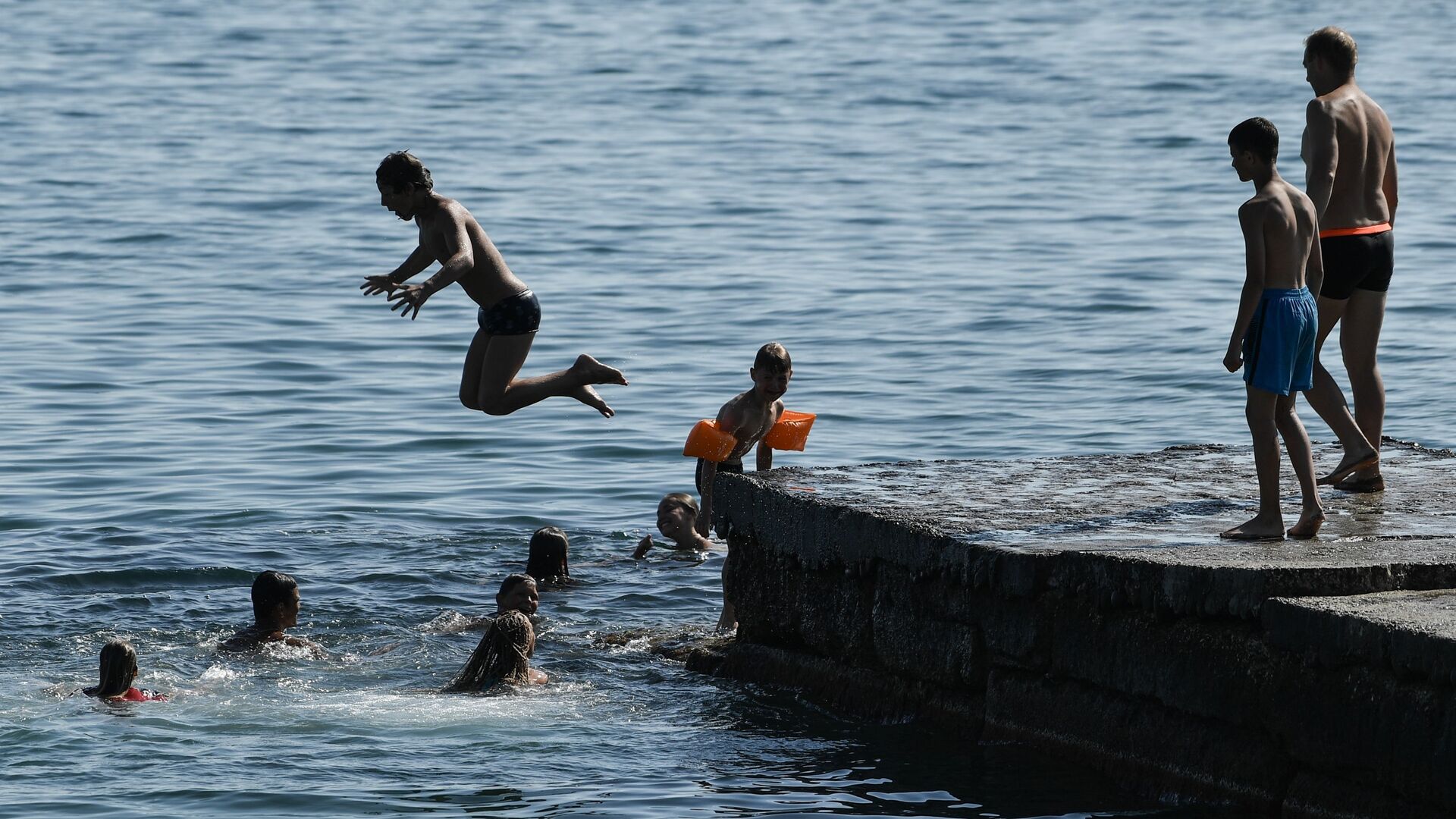 Дети прыгают с пирса на пляже в Судаке - РИА Новости, 1920, 09.06.2022