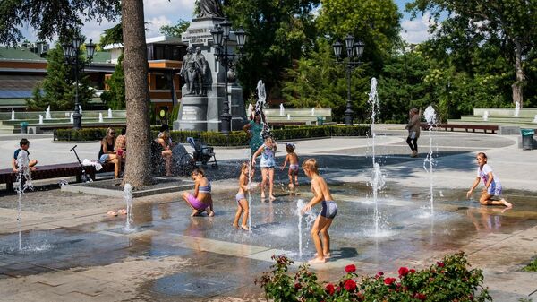 Дети купаются в городском фонтане
