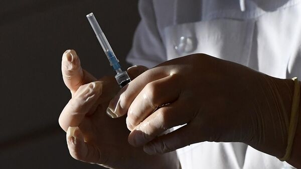 Медицинский работник набирает вакцину