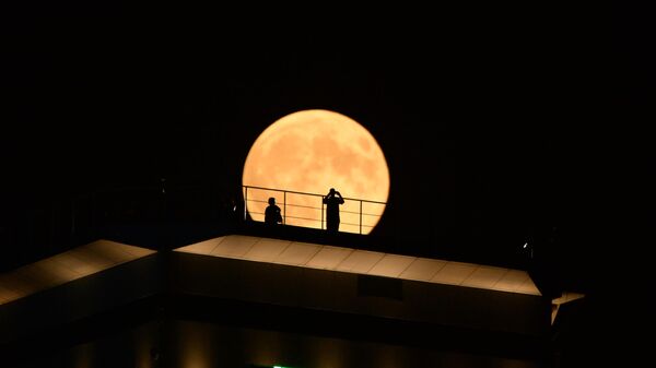 Полное лунное затмение 2018 года. Луна во время затмения на фоне здания высотного комплекса Грозный сити в Грозном