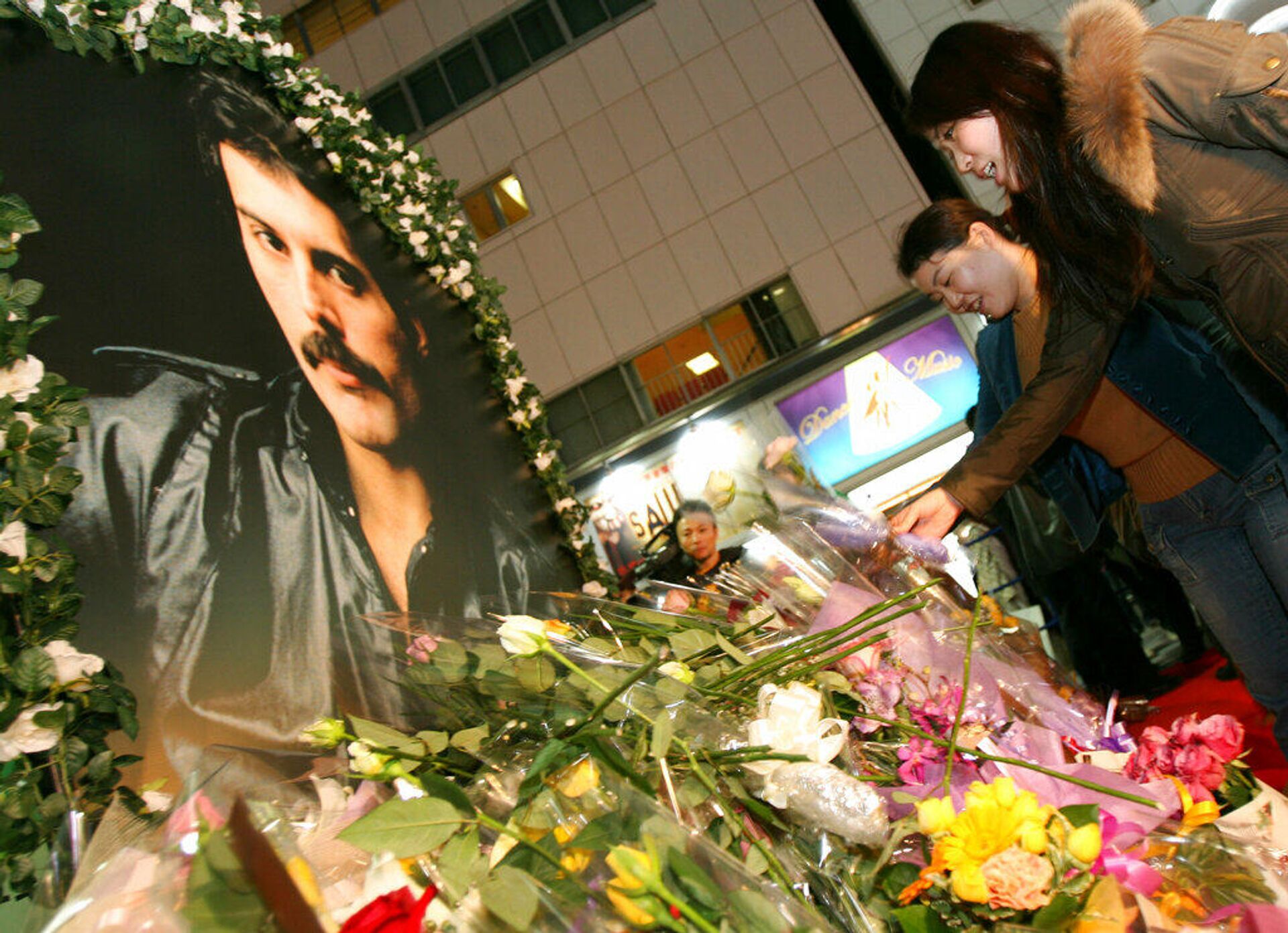 24 ноября 2006 года. Поклонники Фредди Меркьюри возлагают цветы к портрету певца в Токио в 15-ю годовщину его смерти - РИА Новости, 1920, 22.11.2021