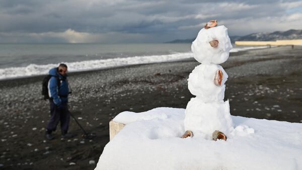 Снеговик на пляже после снегопада на черноморском побережье Сочи, Россия. 