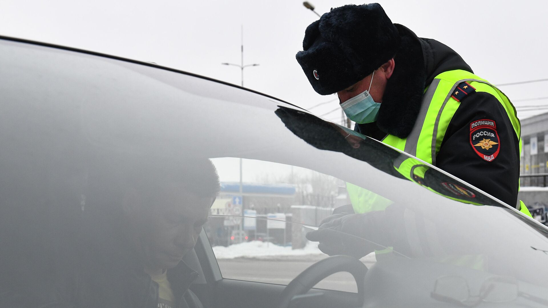 Сотрудник ДПС ГИБДД во время проверки соблюдения масочного режима водителями такси в Новосибирске - РИА Новости, 1920, 05.12.2022