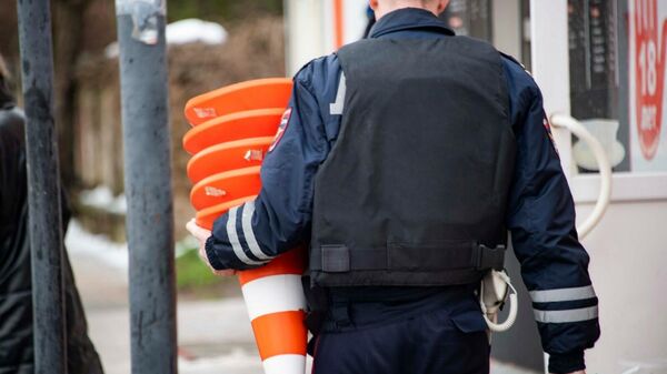 Сотрудник полиции выставляет ограждения возле школы в Крыму после сообщения о минировании