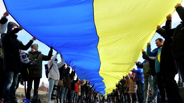 Сторонники Украины несут большой украинский флаг на Карловом мосту в Праге. 22 января 2022 года