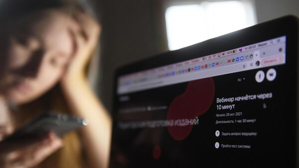 Девушка со смартфоном возле ноутбука