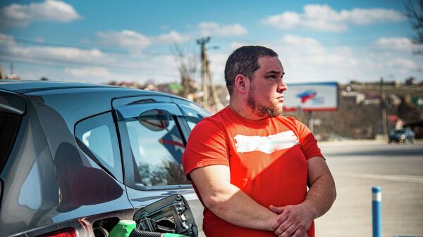 Мужчина заправляет автомобиль бензином