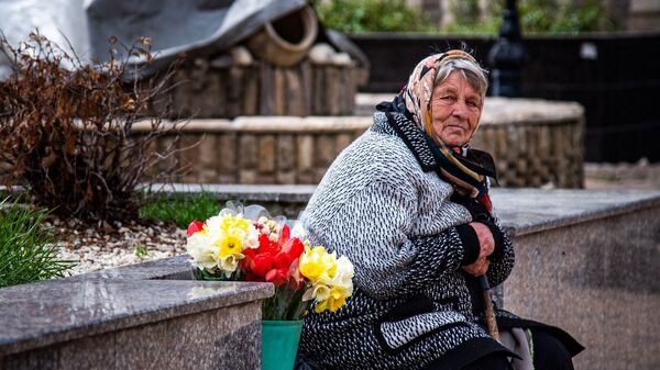 Пожилая женщина продаёт цветы