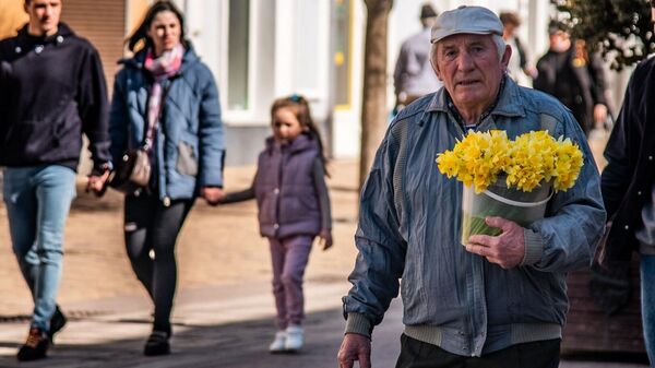 Пожилой мужчина с ведром цветов