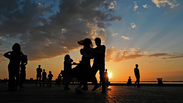 Люди танцуют на набережной