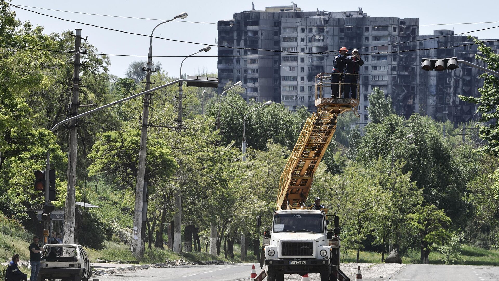 Электромонтеры восстанавливают электроснабжение на одной из улиц в Мариуполе - РИА Новости, 1920, 27.05.2022