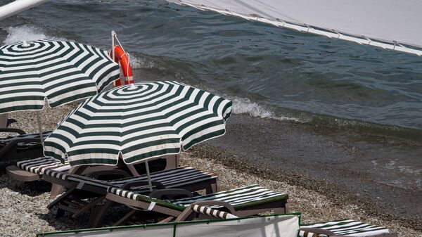 Шезлонги и зонтики на пляже в Алуште