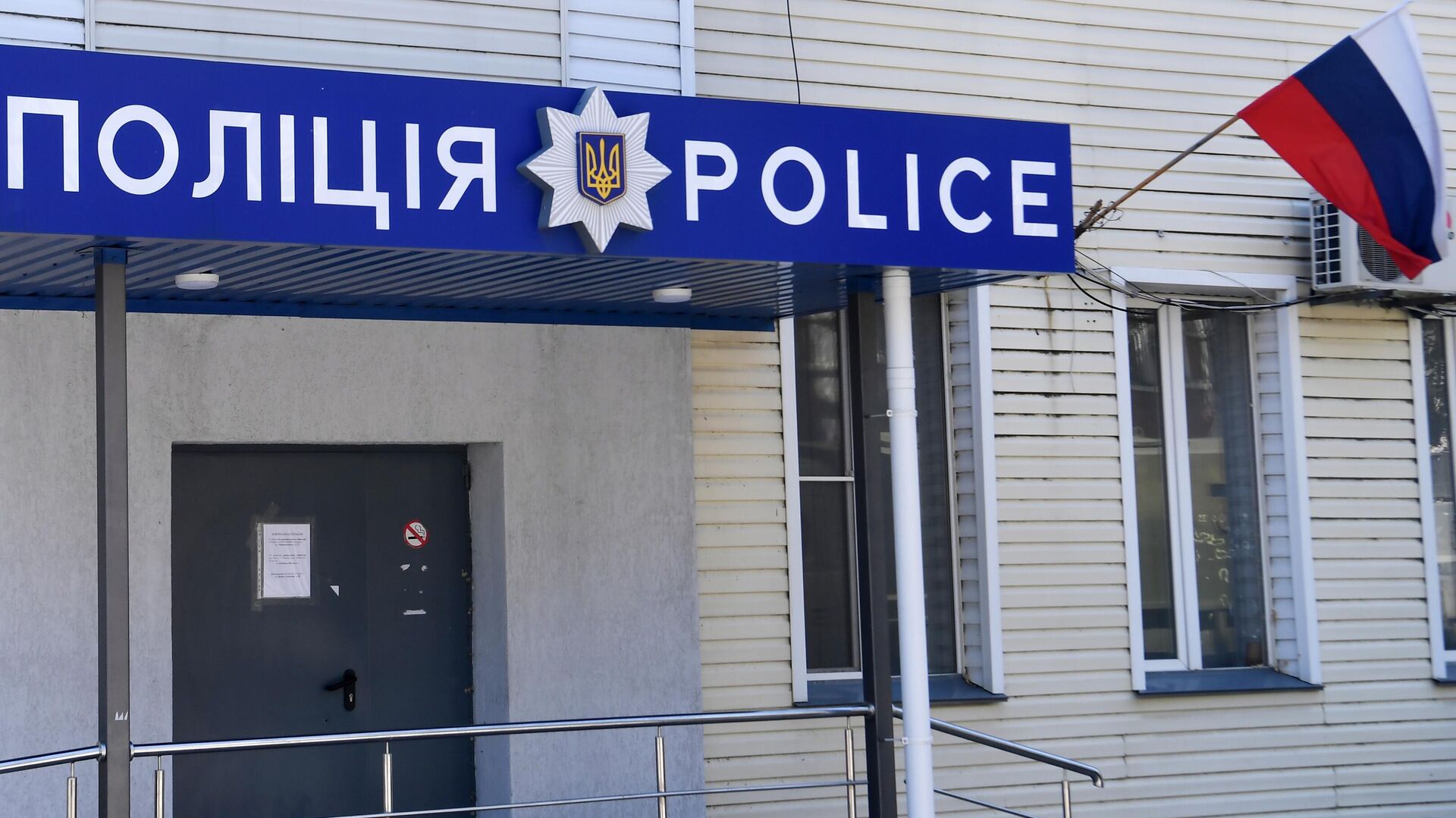 Российский флаг у входа в отделение полиции в Мелитополе. - РИА Новости, 1920, 15.07.2022