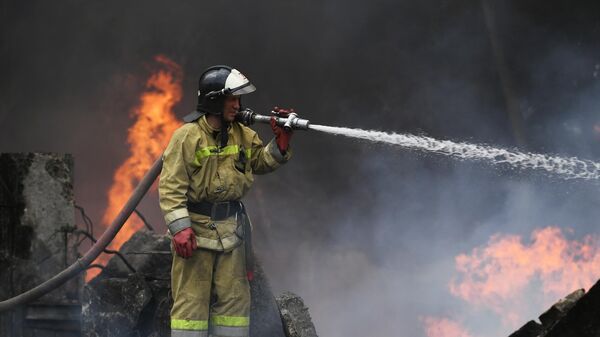 Сотрудник МЧС тушит пожар после обстрелов со стороны ВСУ. Архивное фото