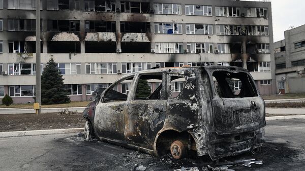 Сгоревший автомобиль и поврежденное административное здание у Запорожской атомной электростанции в Энергодаре