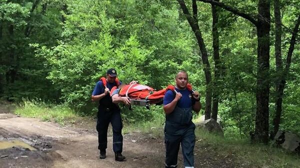 Сотрудники Алуштинского аварийно-спасательного отряда Крым-Спас несут пострадавшего к машине скорой помощи