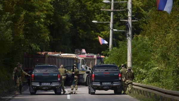 Солдаты НАТО, несущие службу в Косово, рядом с дорожной баррикадой, установленной этническими сербами возле города Зубин-Поток/ Фото Арменда НИМАНИ / AFP