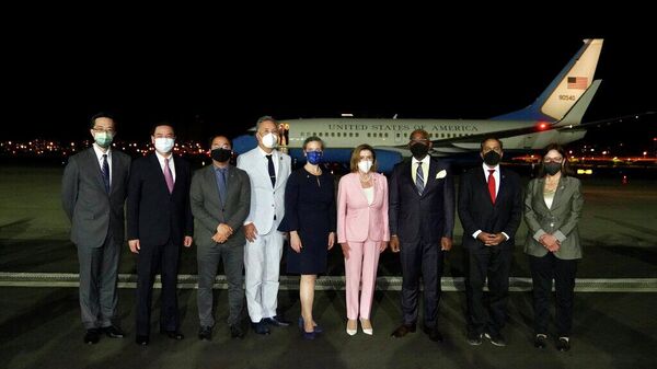 Спикер Палаты представителей США Нэнси Пелоси (в центре) позирует для фотографий после прибытия в Тайбэй, Тайвань
