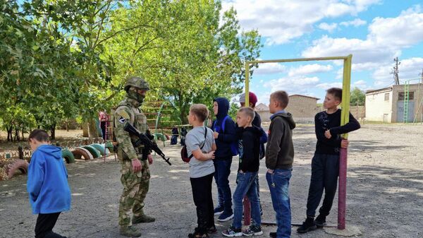 Российские военные с детьми на территории школы в Чаплинке Херсонской области 
