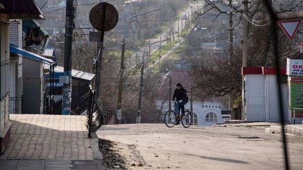 Мужчина едет на велосипеде по дороге в Васильевке, Запорожская область