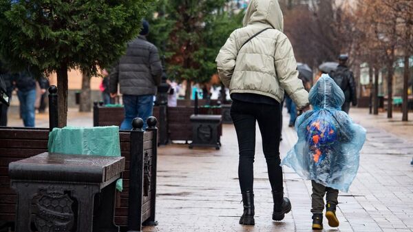 Мама с ребёнком в центре Симферополя во время дождя