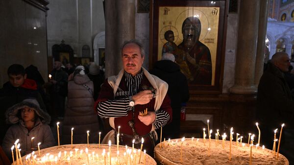 Верующий на православной рождественской службе в кафедральном соборе Самеба в Тбилиси 