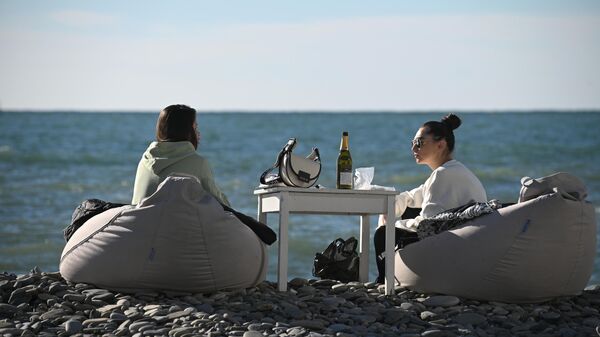 Отдыхающие на галечном пляже у Черного моря в Сочи