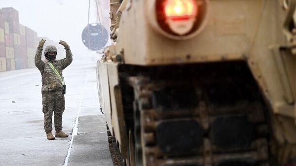 Солдат армии США указывает путь боевому танку M1A2 Abrams.