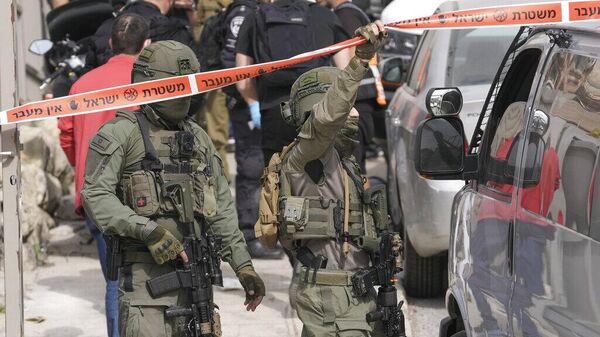 Израильские полицейские охраняют место перестрелки в восточном Иерусалиме, суббота, 28 января 2023 г