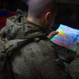 Военнослужащий читает письмо, присланное детьми на фронт