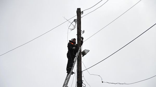 Электрик восстанавливает линию электропередачи после обстрела со стороны украинских войск 