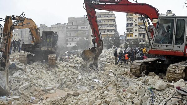Спасатели обыскивают обломки обрушившегося здания в поисках жертв и выживших после смертоносного землетрясения в Сирии